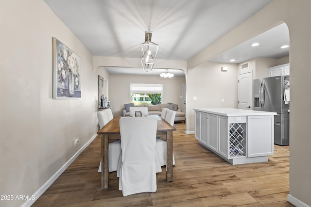 6819 N 10th Pl, Phoenix, AZ 85014 - dining room featuring arched walkways, light wood-type flooring, a chandelier, baseboards, and recessed lighting