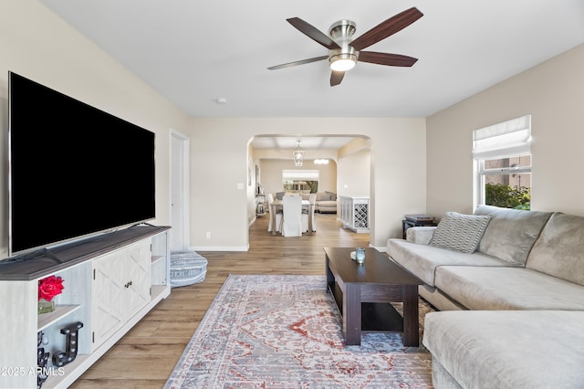 6819 N 10th Pl, Phoenix, AZ 85014 - living room with arched walkways, ceiling fan, light wood finished floors, and plenty of natural light