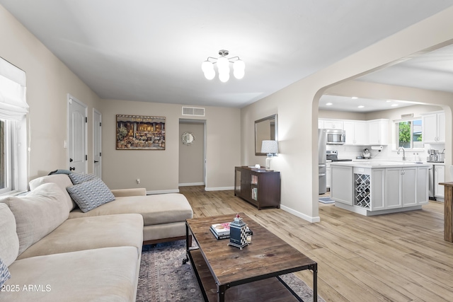 6819 N 10th Pl, Phoenix, AZ 85014 - living area with arched walkways, light wood finished floors, baseboards, and recessed lighting
