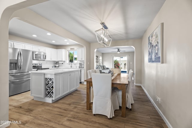 6819 N 10th Pl, Phoenix, AZ 85014 - dining space featuring arched walkways, light wood finished floors, baseboards, ceiling fan, and recessed lighting