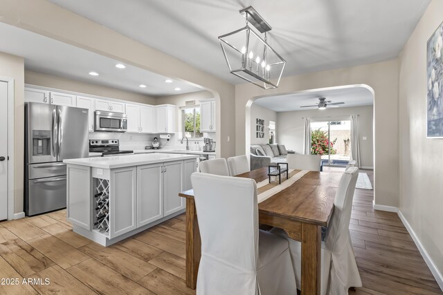 6819 N 10th Pl, Phoenix, AZ 85014 - dining area featuring arched walkways, light wood-style flooring, recessed lighting, and a ceiling fan