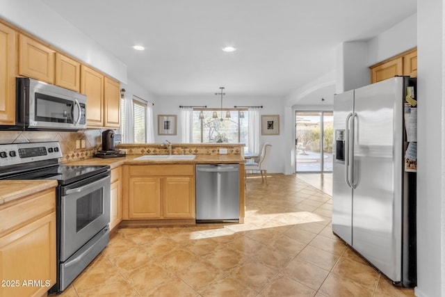 kitchen with sink, decorative backsplash, kitchen peninsula, stainless steel appliances, and light brown cabinets