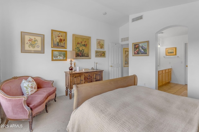 bedroom with connected bathroom and vaulted ceiling