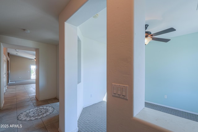 hallway featuring tile patterned flooring and baseboards