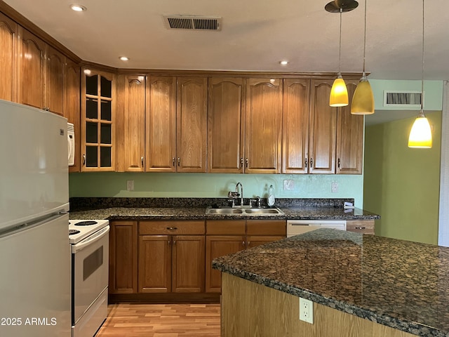 kitchen with white appliances, light wood-style flooring, a sink, and visible vents