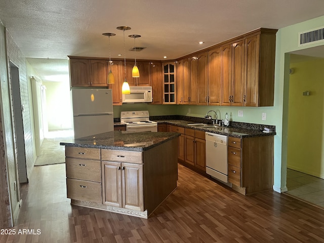 kitchen with white appliances, visible vents, dark wood-type flooring, and a sink