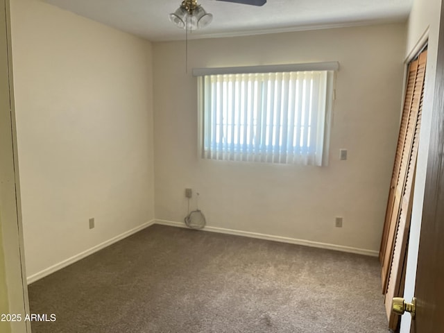 unfurnished bedroom with dark colored carpet, a closet, ceiling fan, and baseboards