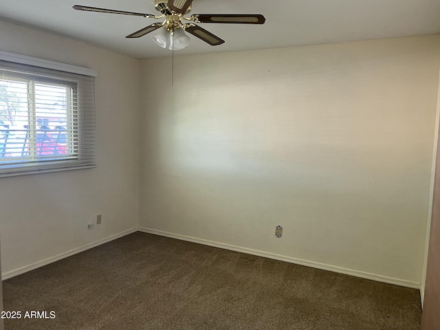 unfurnished room featuring baseboards, dark carpet, and ceiling fan