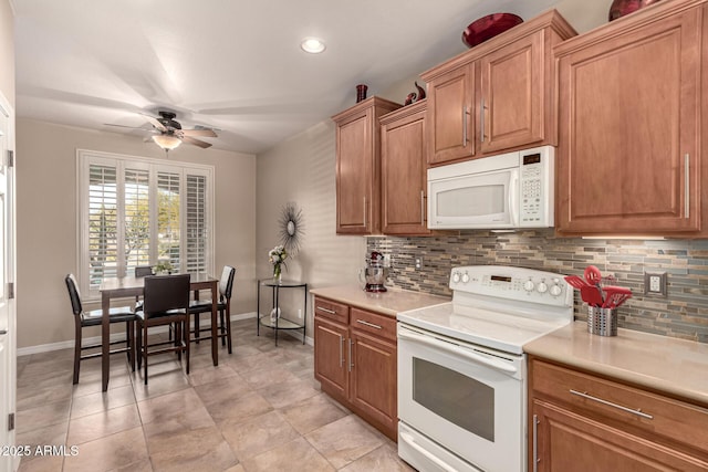 kitchen featuring decorative backsplash, white appliances, and ceiling fan