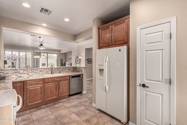 kitchen featuring white fridge with ice dispenser, range, decorative backsplash, sink, and stainless steel dishwasher