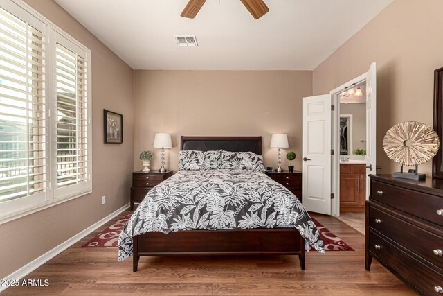 bedroom with light wood-type flooring, ensuite bath, and ceiling fan