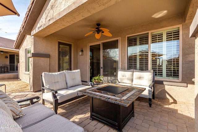 view of patio featuring ceiling fan and an outdoor living space with a fire pit