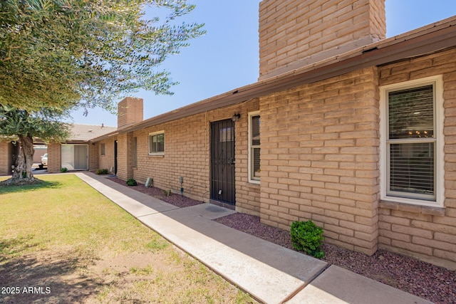 2015 E Southern Ave Unit 16, Tempe, AZ 85282 - view of exterior entry with a chimney and a yard