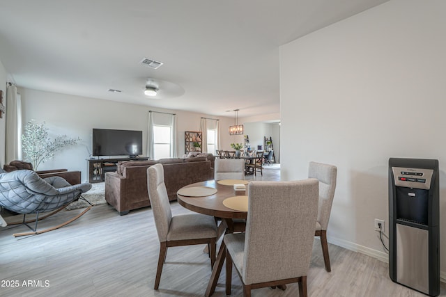dining space featuring light wood-style flooring, baseboards, and visible vents