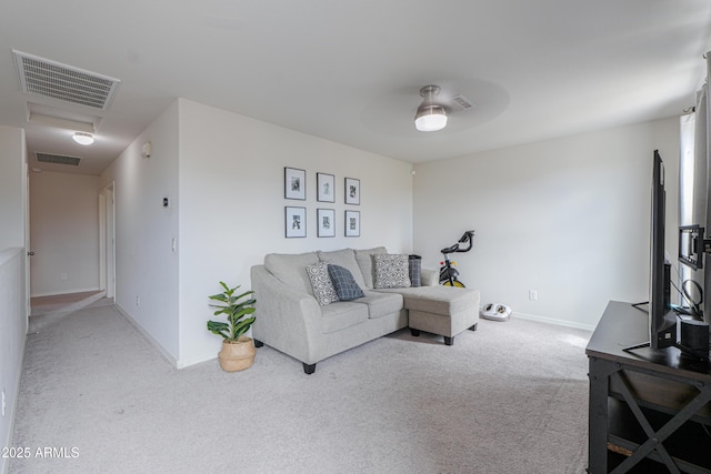 living area featuring baseboards, visible vents, ceiling fan, and carpet