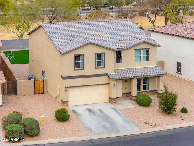 view of front facade featuring a tile roof, concrete driveway, stucco siding, fence, and a garage