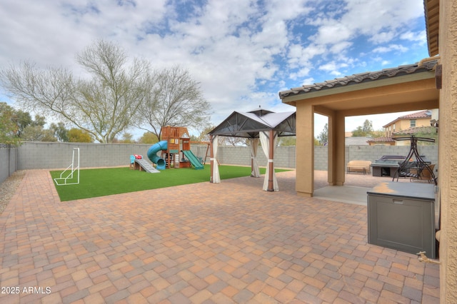 view of patio / terrace featuring a grill, a fenced backyard, a gazebo, and a playground