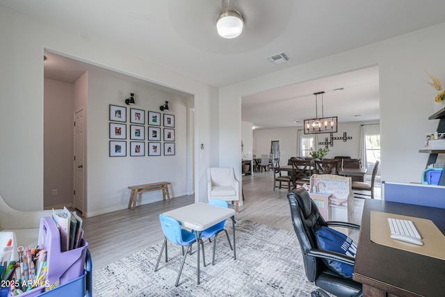 office area with wood finished floors, a notable chandelier, baseboards, and visible vents