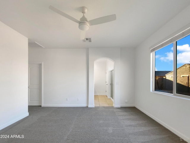 unfurnished room with light colored carpet and ceiling fan