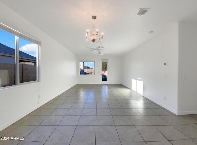 unfurnished living room featuring tile patterned floors, a healthy amount of sunlight, and ceiling fan with notable chandelier