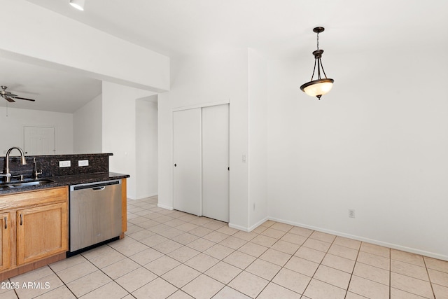 kitchen with baseboards, a ceiling fan, decorative light fixtures, stainless steel dishwasher, and a sink