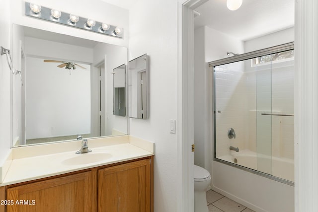 bathroom with tile patterned flooring, toilet, vanity, a ceiling fan, and combined bath / shower with glass door