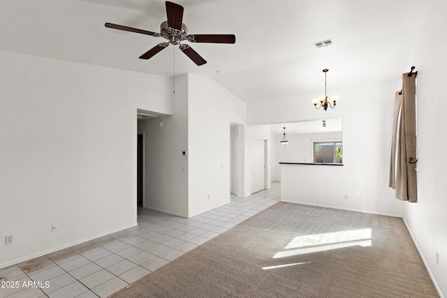 spare room featuring light tile patterned floors, light carpet, ceiling fan with notable chandelier, visible vents, and vaulted ceiling