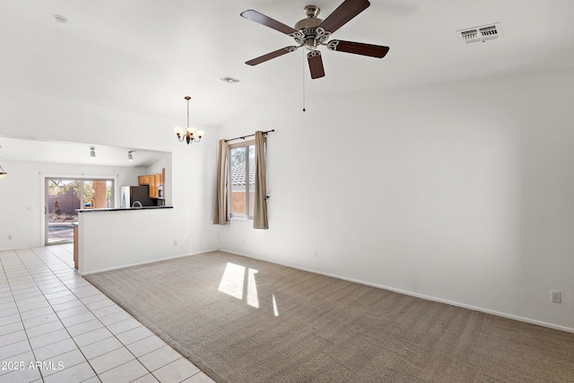 unfurnished room featuring light tile patterned floors, ceiling fan with notable chandelier, visible vents, and light colored carpet