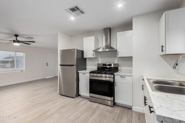 kitchen featuring wall chimney exhaust hood, visible vents, appliances with stainless steel finishes, and a sink