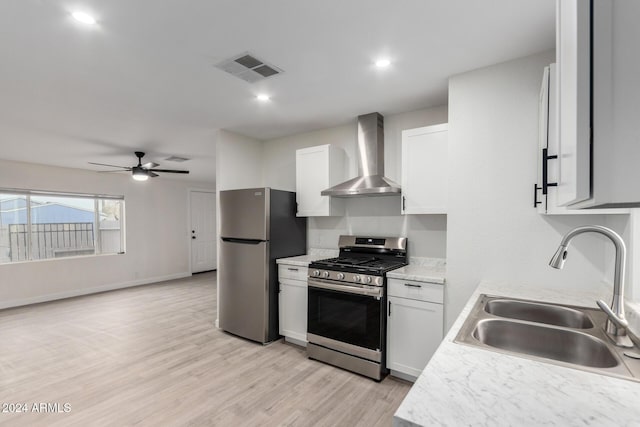 kitchen with visible vents, a sink, stainless steel appliances, wall chimney exhaust hood, and light countertops