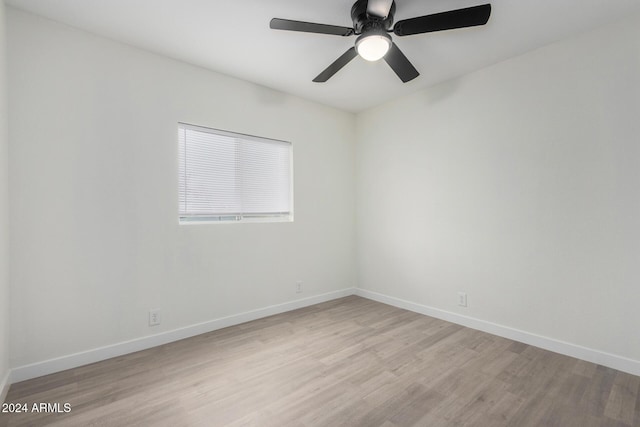 empty room featuring baseboards, light wood-type flooring, and ceiling fan