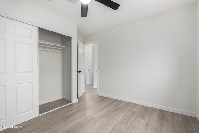 unfurnished bedroom featuring a closet, a ceiling fan, light wood-type flooring, and baseboards