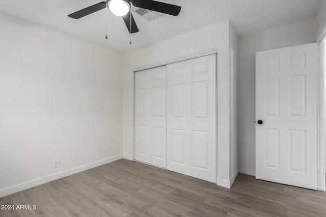 unfurnished bedroom with a closet, baseboards, and wood finished floors