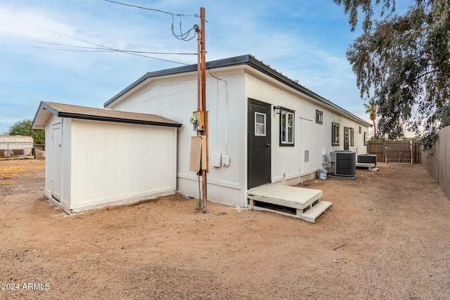 back of property with cooling unit and a fenced backyard