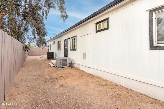 view of side of home featuring central AC and a fenced backyard