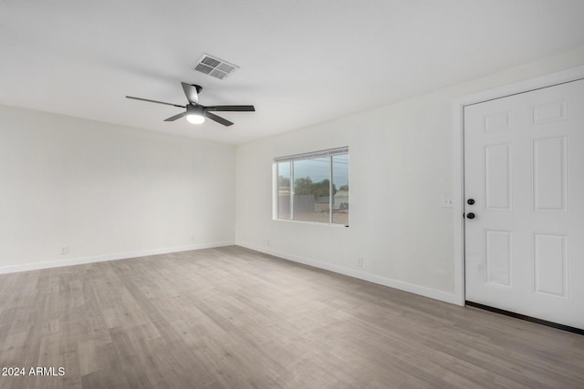 unfurnished room with visible vents, light wood-style flooring, baseboards, and ceiling fan