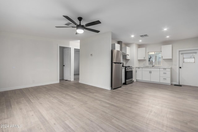 unfurnished living room with a sink, visible vents, baseboards, and light wood-style flooring