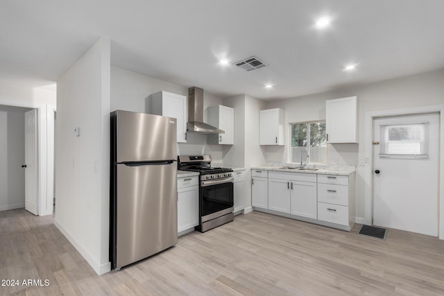 kitchen with a sink, stainless steel appliances, visible vents, and wall chimney exhaust hood