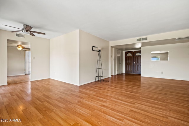 3747 W Aire Libre Ave, Phoenix, AZ 85053 - unfurnished living room featuring a ceiling fan, light wood-style flooring, and baseboards