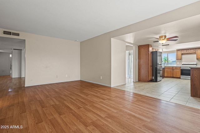 3747 W Aire Libre Ave, Phoenix, AZ 85053 - unfurnished living room with light wood-type flooring, a ceiling fan, baseboards, and a sink