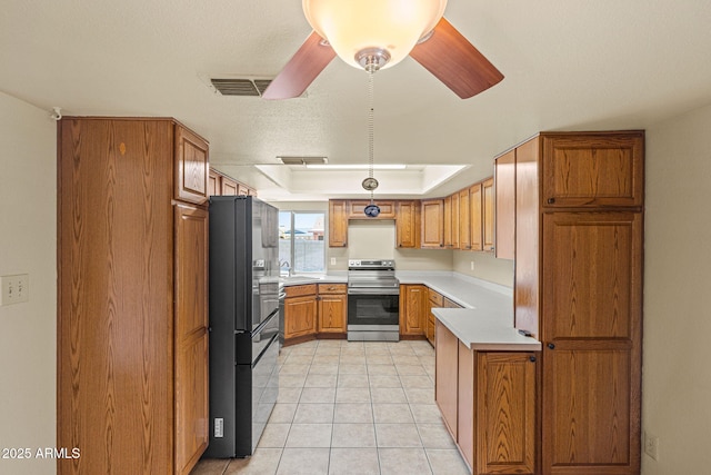 3747 W Aire Libre Ave, Phoenix, AZ 85053 - kitchen featuring stainless steel range with electric cooktop, light countertops, freestanding refrigerator, brown cabinetry, and a sink