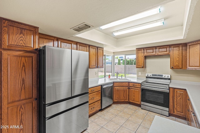 3747 W Aire Libre Ave, Phoenix, AZ 85053 - kitchen with stainless steel appliances, a sink, brown cabinetry, and light tile patterned floors