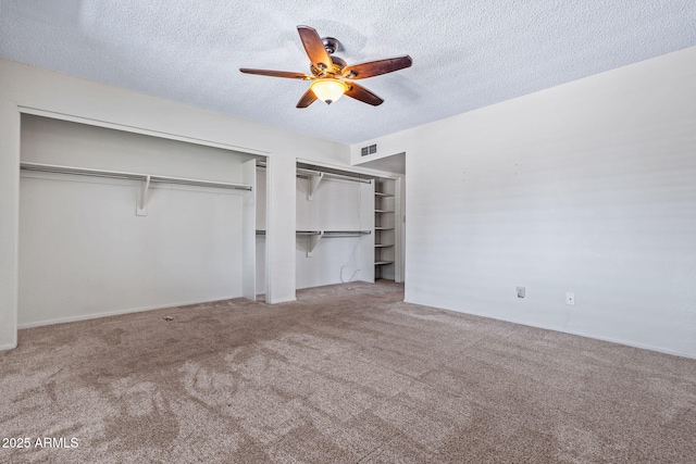 3747 W Aire Libre Ave, Phoenix, AZ 85053 - unfurnished bedroom featuring a textured ceiling, carpet, two closets, and a ceiling fan