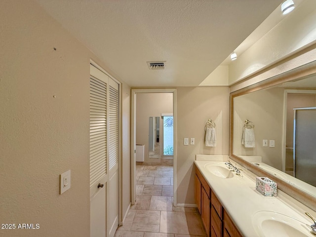 bathroom with a textured ceiling and vanity