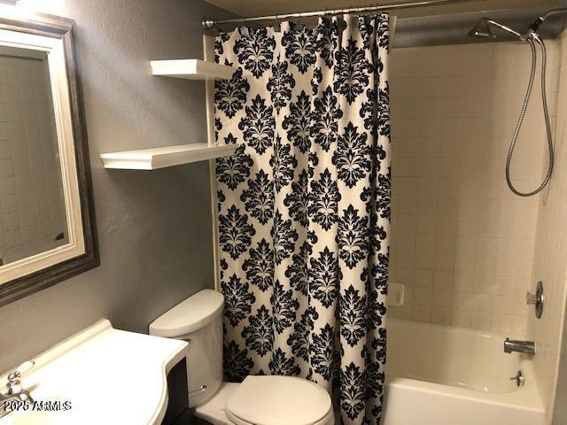 full bathroom featuring vanity, shower / bath combination with curtain, and toilet