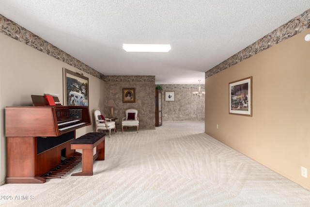 sitting room with a chandelier, carpet floors, and a textured ceiling