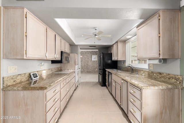 kitchen with ceiling fan, light tile patterned flooring, a sink, dishwasher, and a raised ceiling