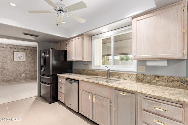 kitchen featuring dishwasher, black fridge with ice dispenser, light stone counters, light brown cabinets, and a sink