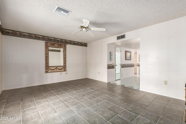 tiled spare room featuring a textured ceiling, visible vents, and a ceiling fan