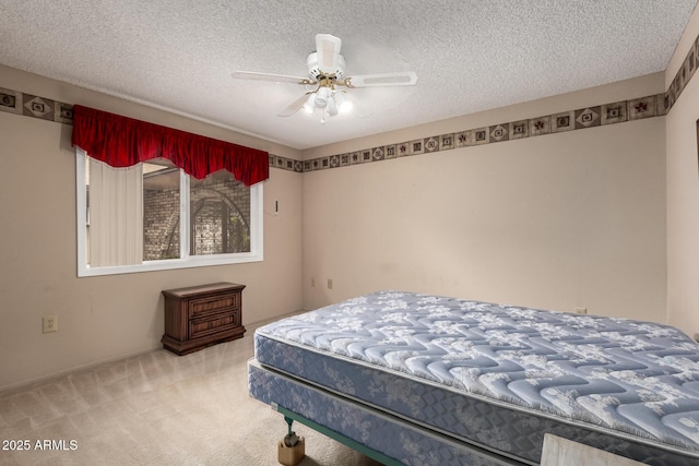 carpeted bedroom featuring ceiling fan and a textured ceiling